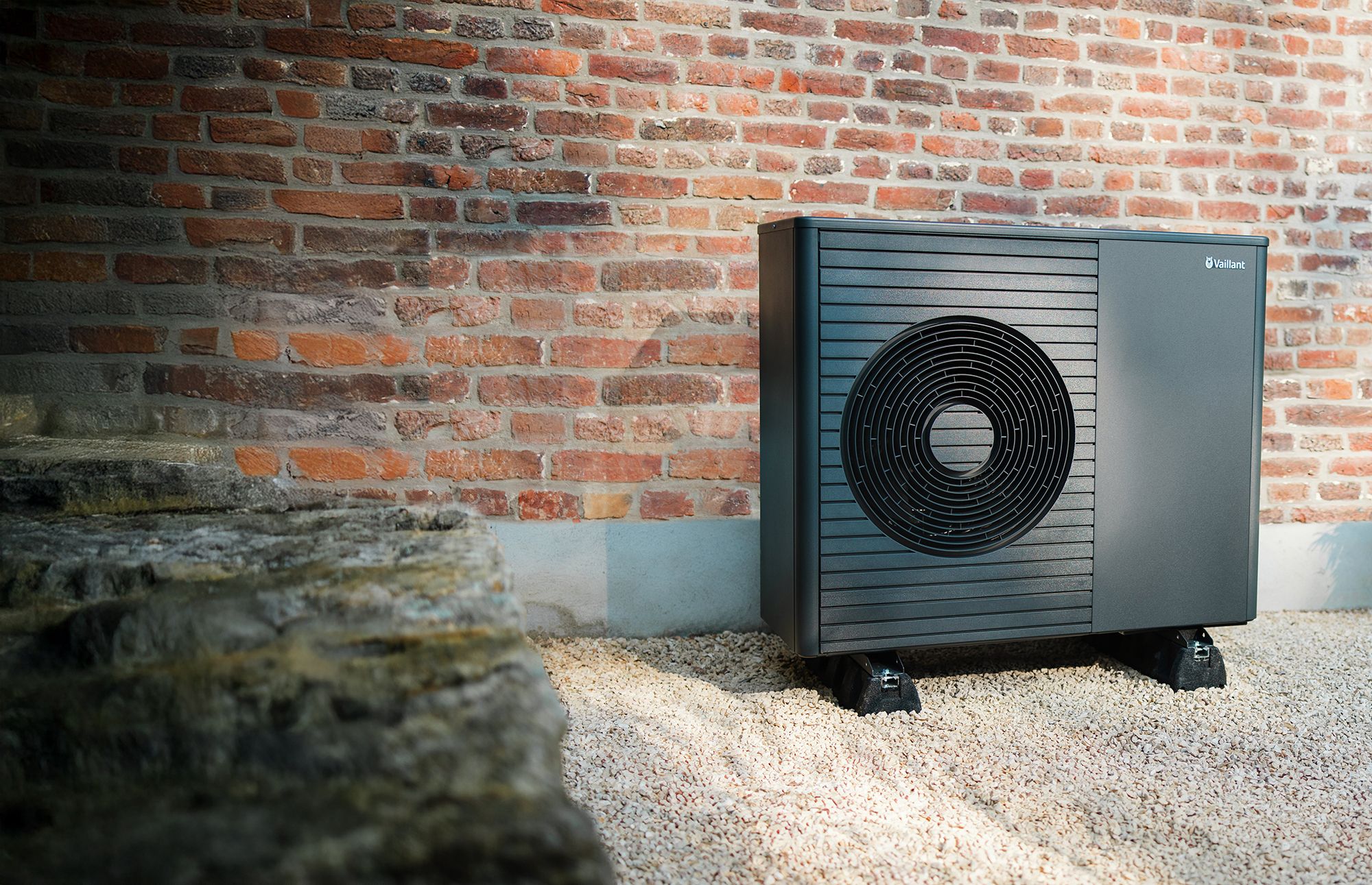 Vaillant-Wärmepumpe auf Kies vor einer roten Backsteinwand